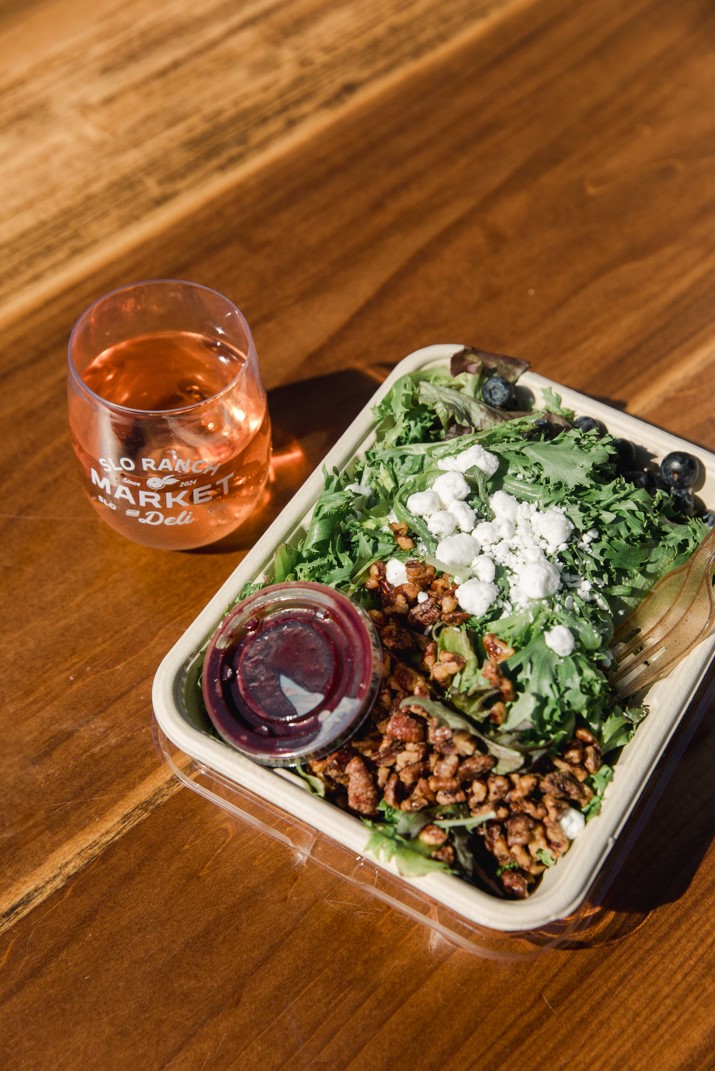 an arugula salad with nuts and cheese, and blueberries